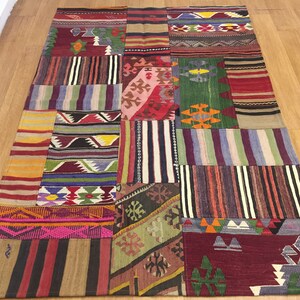 Puede incluir: Una alfombra de patchwork colorida con una variedad de patrones geométricos en tonos de rojo, azul, verde, amarillo y marrón.