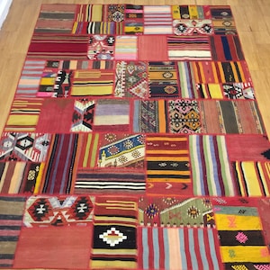 May include: A colorful patchwork rug with a variety of geometric patterns and stripes in shades of red, blue, yellow, and green.