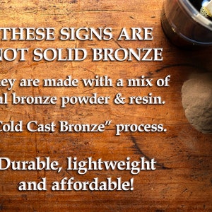 May include: Image of a wooden surface with text stating, "THESE SIGNS ARE NOT SOLID BRONZE." The text explains the signs are made with bronze powder and resin using a "Cold Cast Bronze" process. The text also states the signs are durable, lightweight, and affordable.