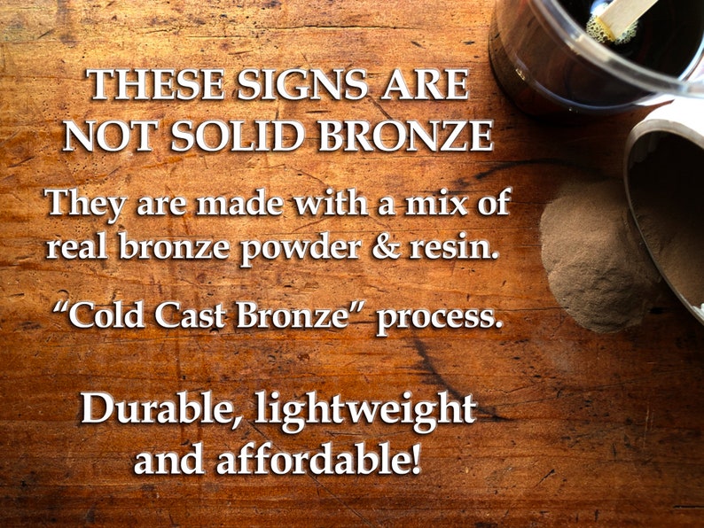 May include: Image of a wooden surface with text stating the signs are not solid bronze, but made with bronze powder and resin using a "Cold Cast Bronze" process. The text also mentions the signs are durable, lightweight, and affordable.