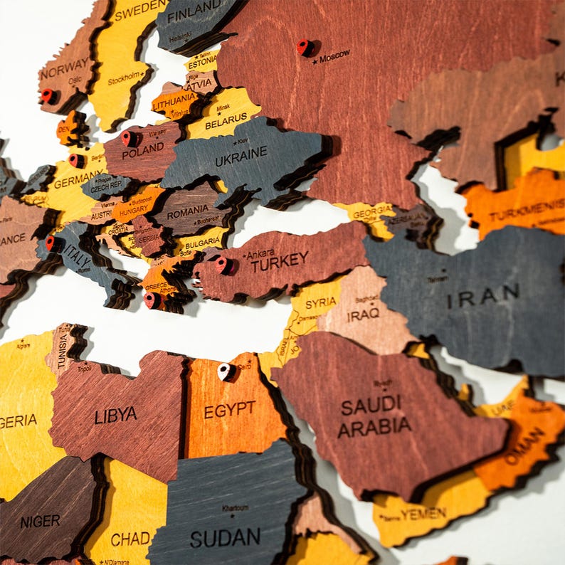 Detail shot of colorful 3D wooden world map — laser-engraved country names across Europe, Middle East and North Africa in vibrant mixed wood tones