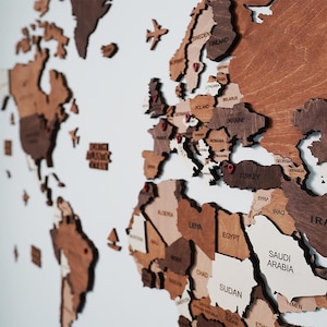 Close-up of 3D wooden world map showing Europe and Middle East with engraved country names in mixed brown tones