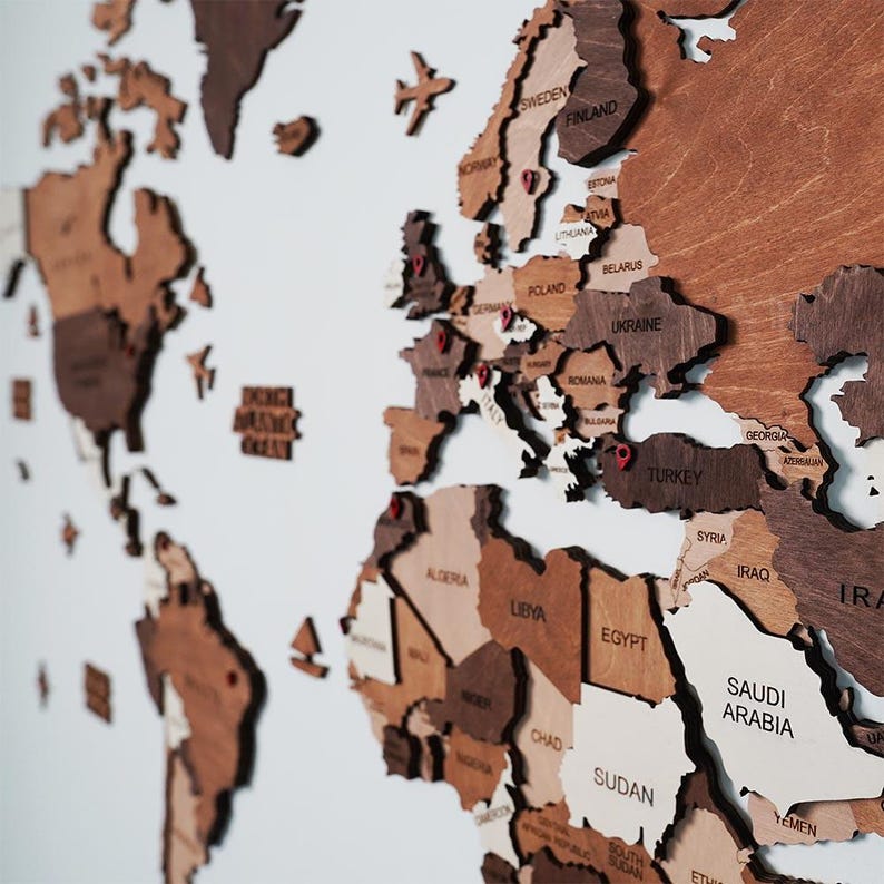 Close-up of 3D wooden world map showing Europe and Middle East with engraved country names in mixed brown tones