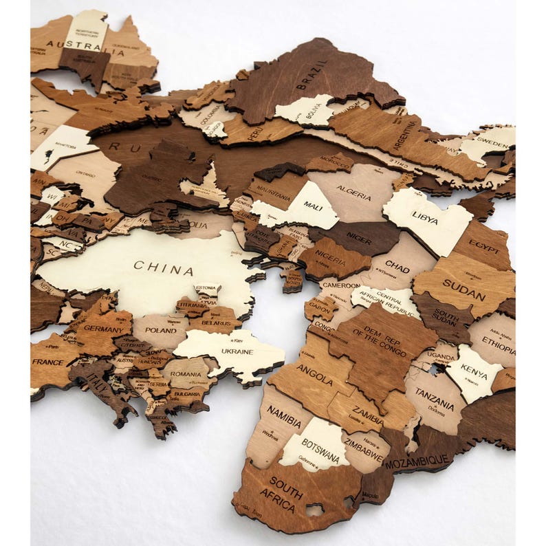 Close-up of 3D wooden world map showing Asia and Africa with engraved country names in mixed brown tones