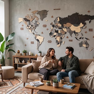 Puede incluir: Un gran mapa del mundo de madera multicapa como arte de pared, con varios tonos de marrón, gris y beige. El mapa incluye continentes cortados con láser, nombres de países, etiquetas de océanos y pequeños iconos decorativos como aviones y barcos.