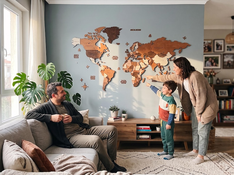 May include: A large, multi-layered wooden world map wall art installation featuring various shades of brown and tan wood. The map includes laser-cut continents, islands, and ocean labels, mounted directly onto a solid light blue wall surface.