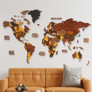 A wooden world map with different colored wood pieces for each country. The map is mounted on a white wall above a brown leather couch. The map includes the names of the continents and oceans.