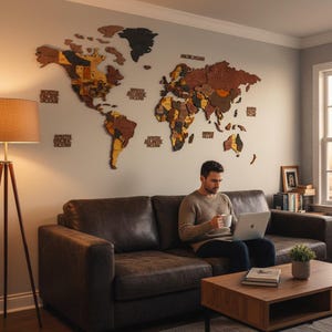 Colorful 3D wooden world map as living room wall decor above sofa — man relaxing with laptop and coffee below large vibrant wood map in warm masculine interior