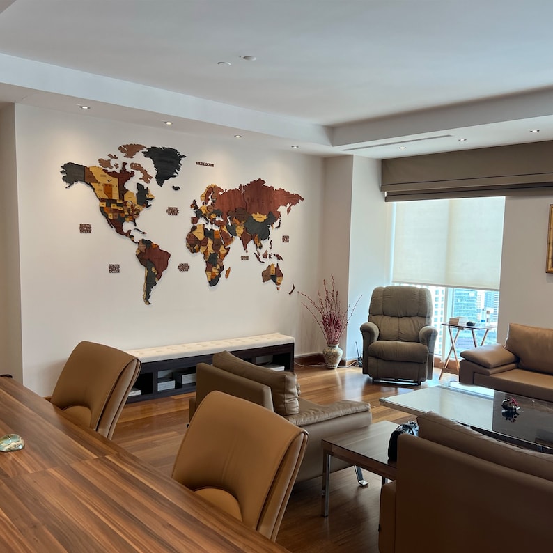 A modern living room with a wooden world map on the wall, a brown leather armchair, a brown leather sofa, and a wooden coffee table. The room has a large window with a view of the city.