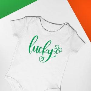 Könnte beinhalten: Weißer Baby-Strampler mit grünem Text "lucky" und einem grünen vierblättrigen Kleeblatt.
