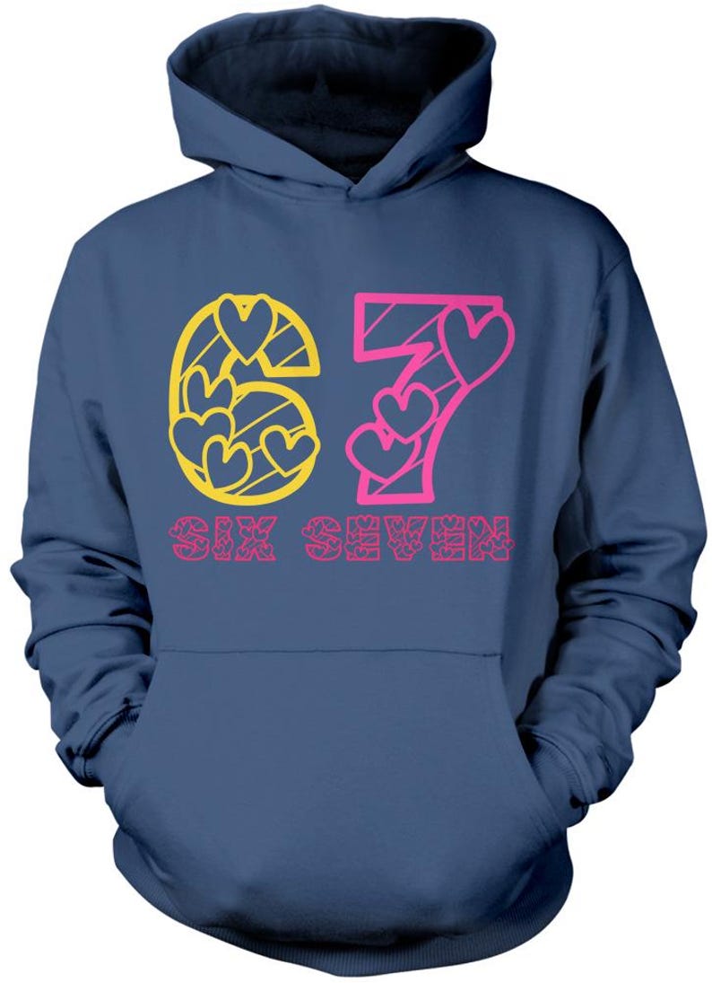 May include: Navy blue hoodie with a front graphic. The graphic features the number "67" in yellow and pink, with heart shapes incorporated into the design. The words "SIX SEVEN" are printed below the numbers in pink.