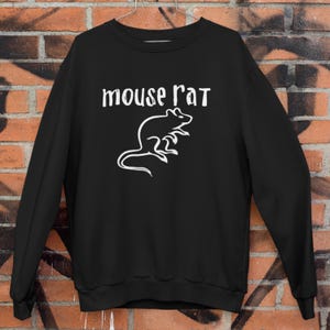 Peut inclure: Sweat-shirt noir avec l'inscription blanche "mouse rat" au-dessus d'un dessin au trait blanc d'une souris. Le sweat-shirt est fait d'une matière douce et a un col rond.
