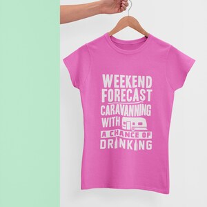 May include: Pink t-shirt with white text that reads "Weekend Forecast: Caravanning with a chance of drinking". The text includes a small graphic of a camper.