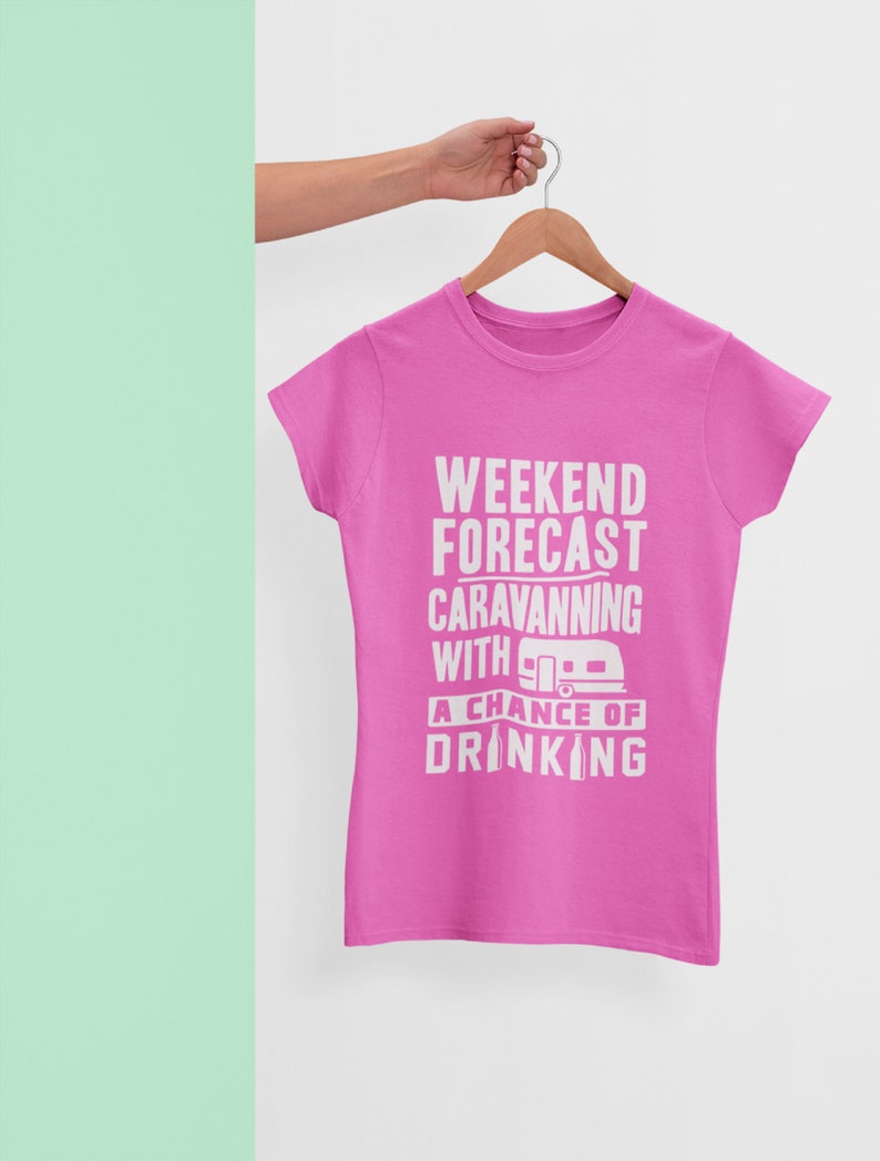May include: Pink t-shirt with white text that reads "Weekend Forecast: Caravanning with a chance of drinking". The text includes a small graphic of a camper.
