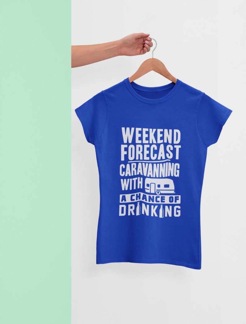 May include: A royal blue t-shirt with a white graphic that reads "Weekend Forecast: Caravanning with a chance of drinking". The graphic also includes a small illustration of a camper van and a beer bottle.