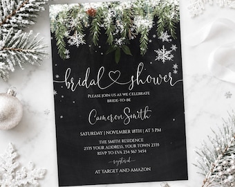May include: A rectangular bridal shower invitation card with a black chalkboard background, featuring white text and a top border of green pine branches dusted with snow and white snowflakes. The text includes the name Cameron Smith.