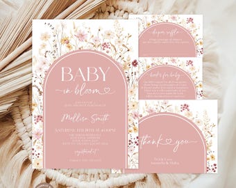 May include: A set of baby shower stationery featuring a dusty rose arch design with white text and watercolor wildflowers. The main invitation reads Baby in Bloom, Mellisa Smith, Saturday Feb 18th at 4:00PM, with additional cards for a diaper raffle and books.