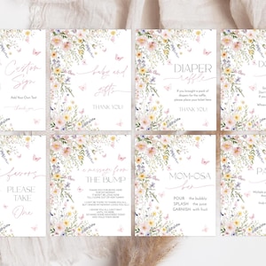 May include: Eight printable baby shower signs with a floral design featuring pink and yellow flowers, butterflies, and green leaves. The signs include text such as "Custom Sign", "Baby and Gifts", "Diaper Raffle", "Don't Say Babe", "Favors Please Take One", "A Message From The Bump", "Mom-osa Bar", and "Pacifier Hunt".