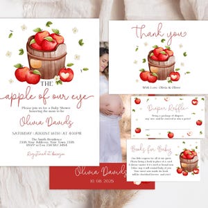 Może przedstawiać: Zestaw zaproszeń na baby shower z akwarelowymi czerwonymi jabłkami w drewnianym koszyku, z napisem The apple of our eye, Olivia Davids oraz szczeg&oacute;łami wydarzenia. Zawiera kartkę z podziękowaniami i karty do loterii pieluszkowej.