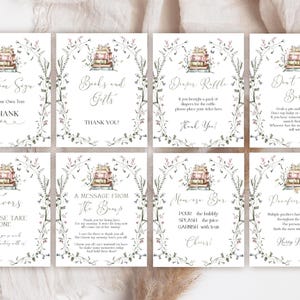 Peut inclure: Un ensemble de huit panneaux rectangulaires blancs pour événements, ornés d'une illustration aquarelle de livres empilés et d'une bordure florale. Chaque panneau comporte du texte imprimé en noir pour diverses activités de fête prénatale, incluant Custom Sign, Books and Gifts, Diaper Raffle, Don't Say Baby, Favors, A Message From The Bump, Mimosa Bar et Pacifier Hunt.