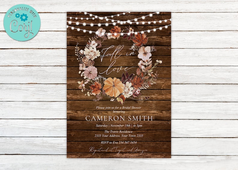 May include: Fall-themed bridal shower invitation with a rustic wood background. The invitation features a wreath of fall leaves and flowers with the text "Fall in love" in a handwritten font. The invitation also includes the bride's name, the date and time of the shower, the location, and RSVP information.