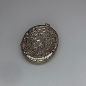 May include: Silver oval locket with an intricate floral design.