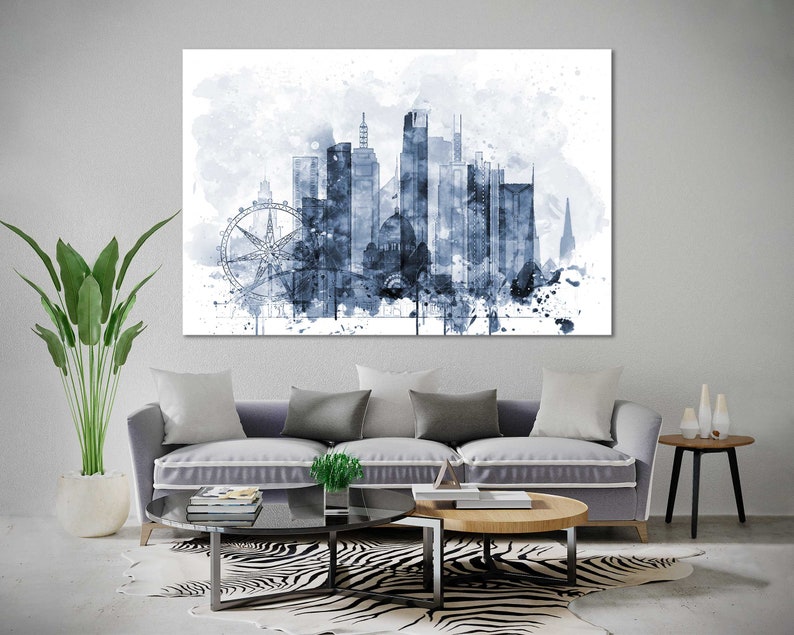 May include: A watercolor painting of a city skyline in shades of blue. The skyline includes tall buildings, a Ferris wheel, and a church steeple. The painting has a white background with splatters of blue paint.