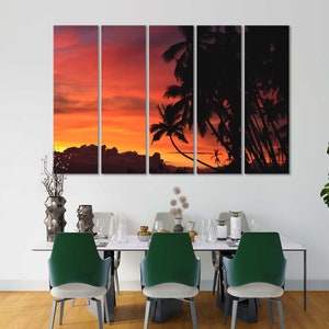 May include: A multi-panel canvas print featuring a sunset over a tropical island with palm trees silhouetted against the orange and red sky.