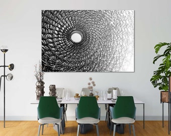 Peut inclure: Impression d'art abstrait en noir et blanc d'un motif géométrique tourbillonnant. Le motif ressemble à une toile d'araignée ou à un filet, avec un cercle blanc au centre. L'impression est encadrée et accrochée à un mur blanc au-dessus d'une table à manger.