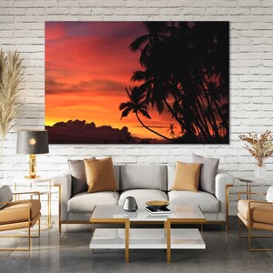 May include: A canvas print of a sunset over a tropical island with palm trees silhouetted against the orange and pink sky.