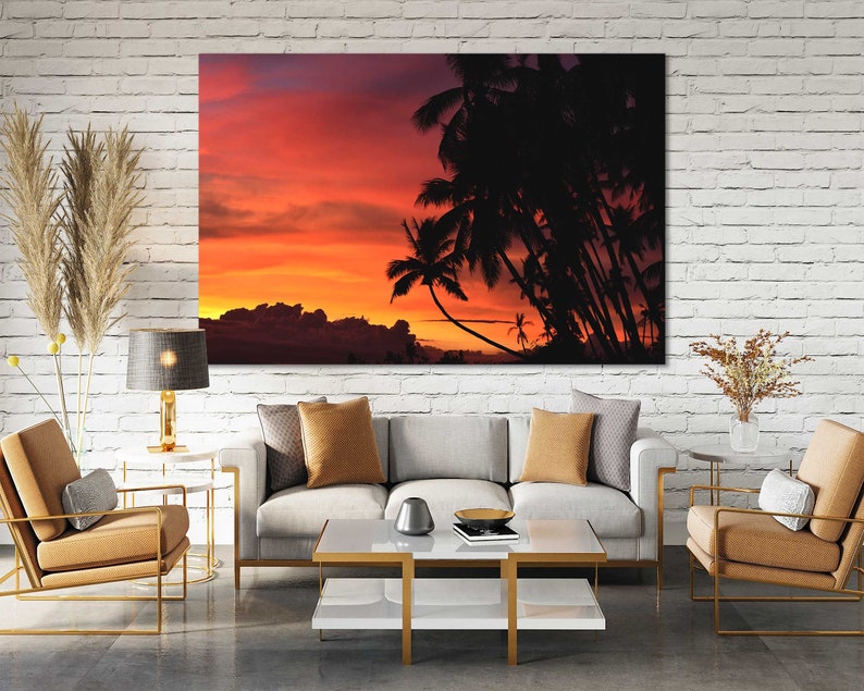 May include: A canvas print of a sunset over a tropical island with palm trees silhouetted against the orange and pink sky.