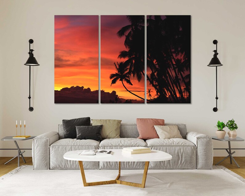 May include: A split-panel canvas print featuring a sunset over a tropical island with palm trees silhouetted against the orange and red sky.