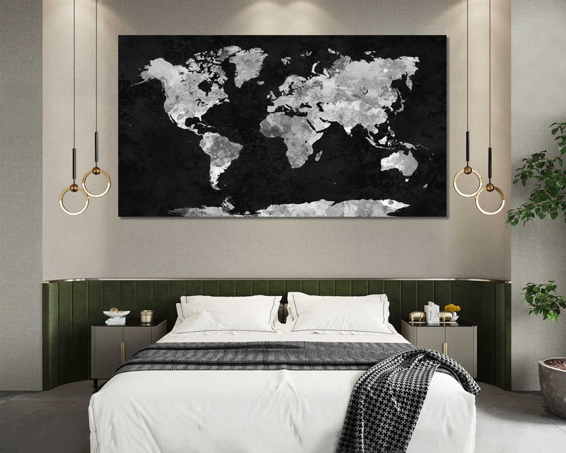 May include: A black and white world map print with a distressed, watercolour effect hangs above a white bed with a green headboard. The bed has a white duvet and a black and white throw blanket.