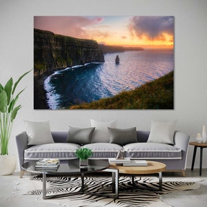 Puede incluir: Una vista panor&aacute;mica de los Acantilados de Moher en Irlanda, con un cielo de puesta de sol dram&aacute;tico y una isla rocosa en la distancia.