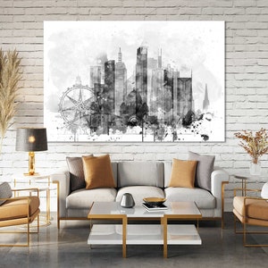 May include: Black and white watercolor painting of a city skyline with a Ferris wheel in the foreground. The skyline is made up of tall buildings and a church steeple. The painting is on a white canvas and is framed in a black frame.