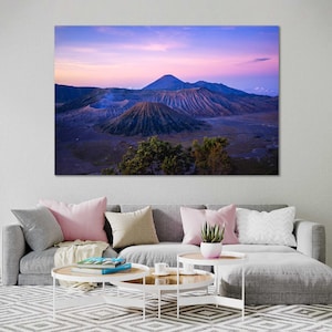 May include: A landscape canvas print depicting a volcanic mountain range under a twilight sky. The artwork features a color palette of purples, blues, and browns, with a focus on the textured volcanic peaks and the soft hues of the sky.