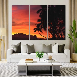 May include: A three-panel canvas print featuring a sunset over a tropical island with palm trees silhouetted against the orange and red sky.