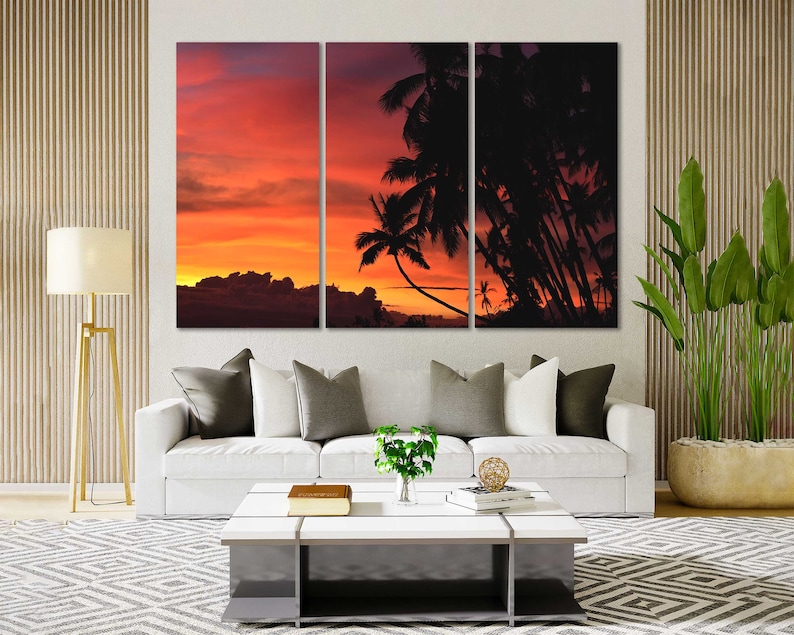May include: A three-panel canvas print featuring a sunset over a tropical island with palm trees silhouetted against the orange and red sky.