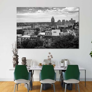 K&ouml;nnte beinhalten: Schwarzwei&szlig;foto einer Skyline mit Geb&auml;uden und B&auml;umen. Das Foto ist gerahmt und h&auml;ngt an einer wei&szlig;en Wand &uuml;ber einem Esstisch mit vier St&uuml;hlen.