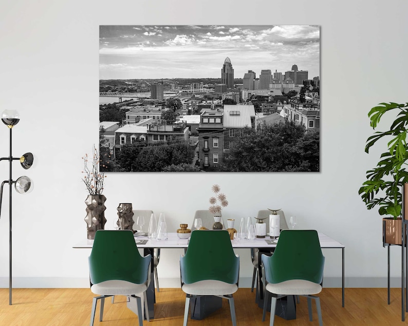K&ouml;nnte beinhalten: Schwarzwei&szlig;foto einer Skyline mit Geb&auml;uden und B&auml;umen. Das Foto ist gerahmt und h&auml;ngt an einer wei&szlig;en Wand &uuml;ber einem Esstisch mit vier St&uuml;hlen.
