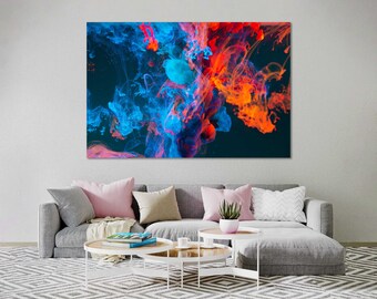 May include: Abstract canvas art featuring vibrant swirls of blue, red, and orange hues against a dark background. The artwork is displayed above a gray sofa with decorative pillows and a patterned rug, creating a modern living room setting.