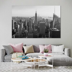 May include: Black and white photograph of the New York City skyline, featuring the Empire State Building and other skyscrapers.
