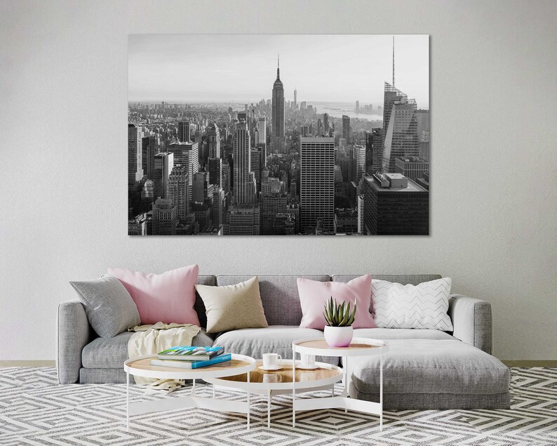 May include: Black and white photograph of the New York City skyline, featuring the Empire State Building and other skyscrapers.
