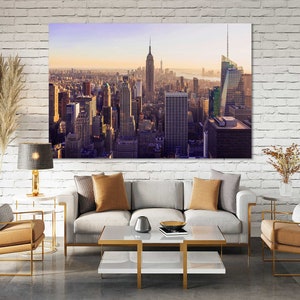 May include: A panoramic view of the New York City skyline at sunset, featuring the Empire State Building and other skyscrapers.