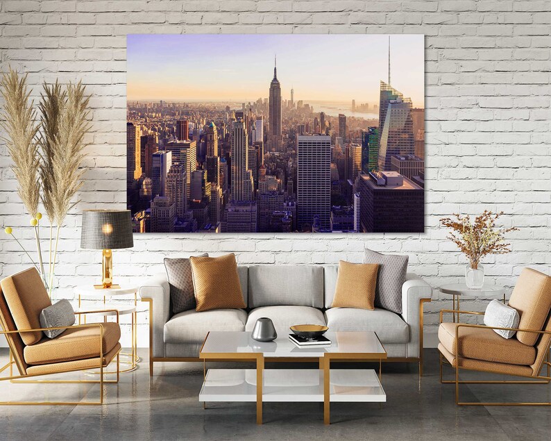 May include: A panoramic view of the New York City skyline at sunset, featuring the Empire State Building and other skyscrapers.