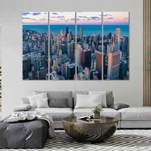 May include: A panoramic view of a city skyline with tall buildings and a blue sky with clouds. The city is seen from above, with the buildings arranged in a grid pattern. The sky is a light blue with white clouds.