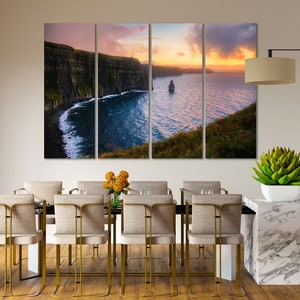 Puede incluir: Una impresi&oacute;n en lienzo de varios paneles que presenta una vista panor&aacute;mica de los Acantilados de Moher en Irlanda. Los acantilados son una formaci&oacute;n rocosa dram&aacute;tica a lo largo de la costa atl&aacute;ntica, con un cielo de puesta de sol vibrante y un oc&eacute;ano tranquilo en primer plano.