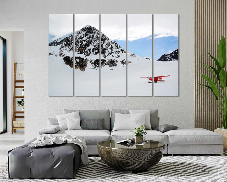 May include: A multi-panel canvas print featuring a snowy mountain landscape with a red airplane flying over a snow-covered field.