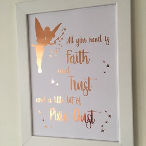 May include: A white framed print with a gold silhouette of Tinkerbell and the quote "All you need is faith and trust and a little bit of pixie dust".
