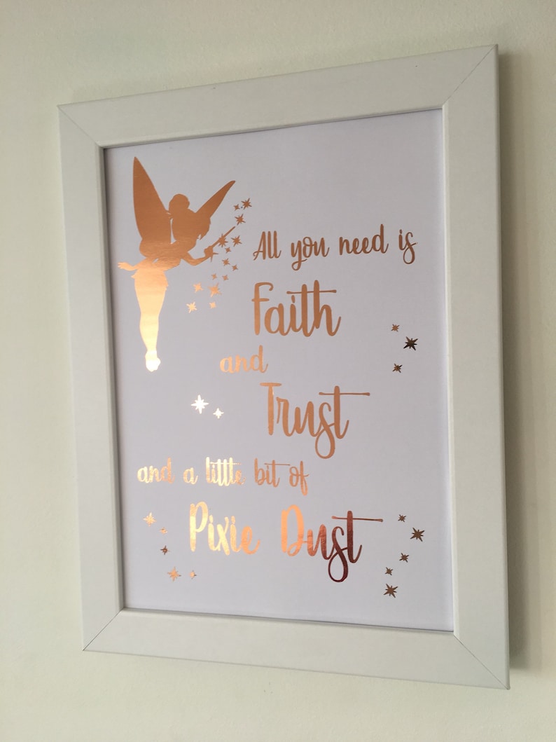 May include: A white framed print with a gold silhouette of Tinkerbell and the quote "All you need is faith and trust and a little bit of pixie dust".